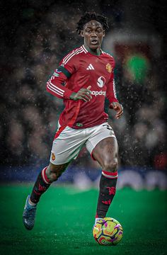 a soccer player is running with the ball in his hand while it rains on the field