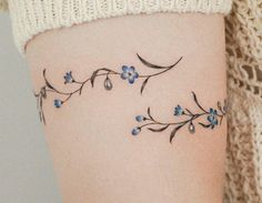 a woman's thigh with blue flowers on it