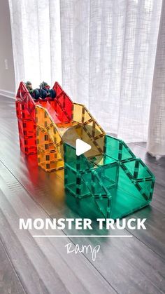 a toy truck made out of plastic blocks on the floor with text overlay reading monster truck