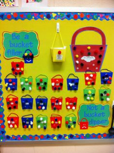 a bulletin board with lots of colorful magnets on it and a bucket hanging from the wall