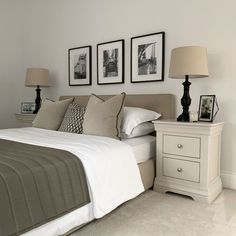 a white bed sitting next to two pictures on the wall