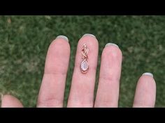 a person's hand with a ring on top of it and grass in the background