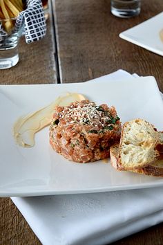 a white plate topped with two pieces of bread next to each other on top of a wooden table