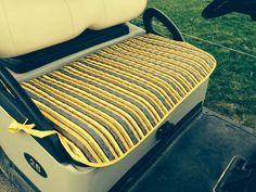 a yellow and blue striped seat cover on a golf cart