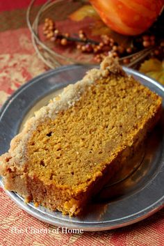 a piece of cake sitting on top of a metal plate next to some pumpkins