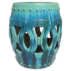 a blue ceramic vase with holes in the middle