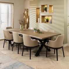 a dining room table surrounded by beige chairs