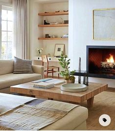 a living room filled with furniture and a fire place in the middle of the room