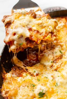 a close up of a slice of pizza being lifted from a skillet with a spatula