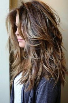 Woman with layered hair highlighting a modern tousled hairstyle with mixed brown tones. Long Hair Choppy Layers Straight, Long Layered Haircuts Shag, Beachy Layered Hair, Long Hair With Shaggy Layers, Long Length Hair With Layers Wavy, Textured Long Haircut, Cuts For Wavy Hair Medium, Haircuts For Long Hair Layers, Long Hair With Choppy Layers