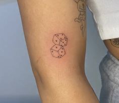 a woman's leg with dice tattoo on the left side of her arm, which is black and white