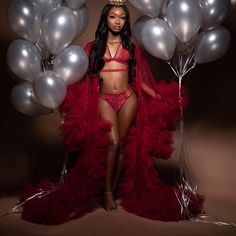 a woman in a red outfit and some silver balloons