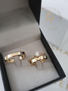 two gold rings with diamonds in a box