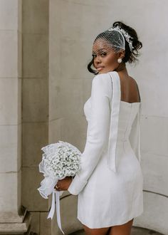 a woman in a white dress holding a bouquet of flowers