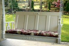 a white porch swing with pillows on it