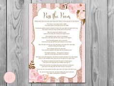 a pink and gold wedding poem with roses on the bottom, in front of a wooden background