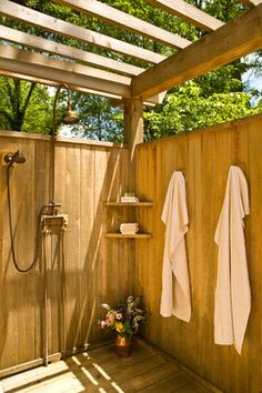 a wooden shower with two white towels hanging on the wall