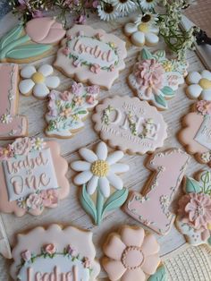 some decorated cookies are sitting on a table with flowers and other items in the background