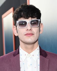 a young man wearing sunglasses and a suit