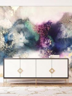 a large painting on the wall behind a white cabinet in front of a beige rug