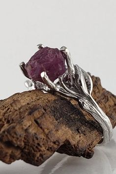 a close up of a ring on a piece of wood with a stone in the middle