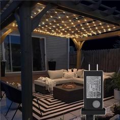 an outdoor living area with patio furniture and string lights on the pergolated roof