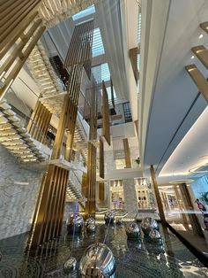 the interior of a modern building with marble flooring and metal railings that are suspended from the ceiling