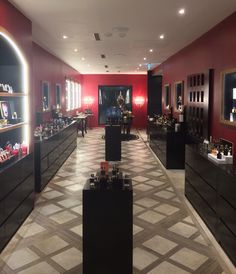 the inside of a jewelry store with red walls and flooring, lighted by recessed lights