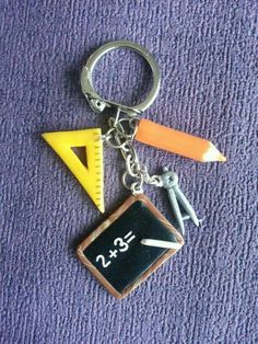 a keychain with a chalkboard, pencils and an eraser on it