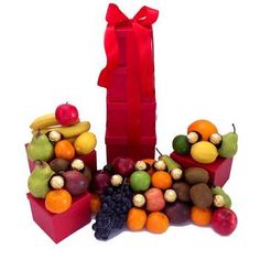 a red box filled with lots of different types of fruit next to a large bow