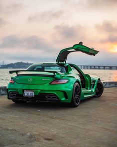 a green mercedes sports car parked on the beach