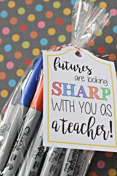 some pens are sitting on top of each other with a sign that says futures are looking sharp with you as teacher