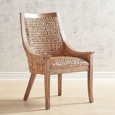 a wicker chair sitting on top of a hard wood floor next to a wall