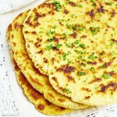 three flat breads on a white doily with parsley sprinkled on top