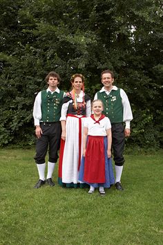 a group of people standing next to each other on a lush green field