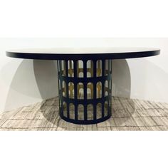 a round table with an intricate design on it's top and bottom, against a white wall