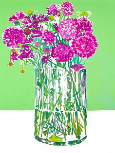 a glass vase filled with purple flowers on top of a white tablecloth next to a green wall