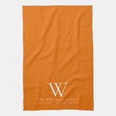 an orange beach towel with the letter w on it and a white monogrammed logo