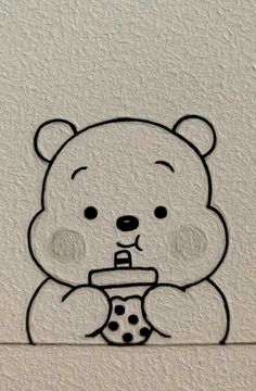 a drawing of a teddy bear with a cup in its mouth, on the wall