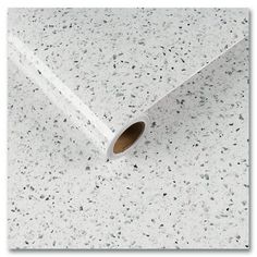 a roll of white paper with black speckles on the top and bottom of it