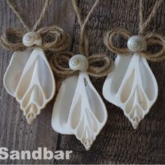 three white ceramic ornaments hanging from twine