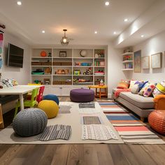 a living room filled with lots of furniture and colorful pillows on top of the floor