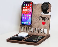 a cell phone and mouse in a wooden holder with the word papa attached to it