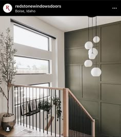 a room with some lights hanging from it's ceiling and a plant in the corner