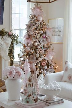 a decorated christmas tree in a living room with pink and gold ornaments on it's branches