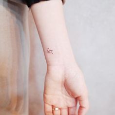 a small bow tattoo on the wrist is shown in this image, it's simple and elegant