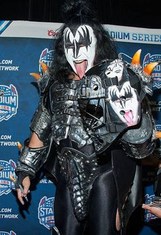 a man with his mouth open and face painted like kiss on the cheek, standing in front of a stage backdrop