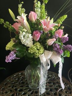 a vase filled with lots of flowers on top of a table