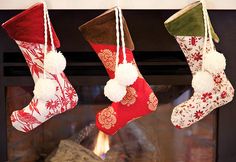 three christmas stockings hanging from a fireplace