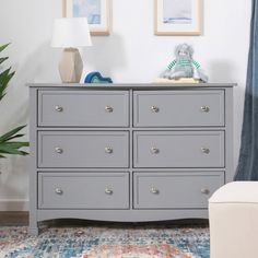 a grey dresser in a living room with blue curtains